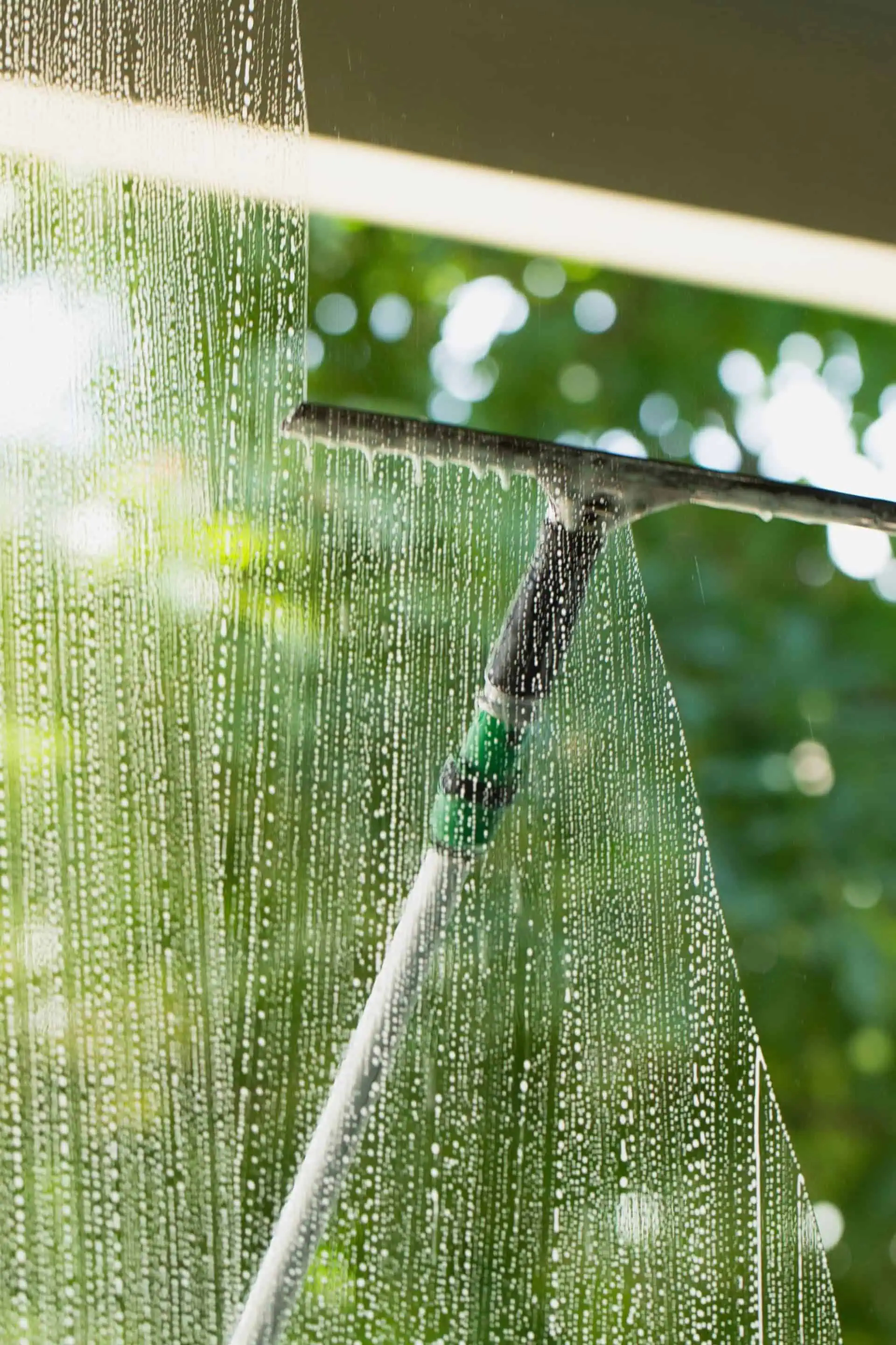 Water-fed pole with squeegee cleaning exterior window for streak-free finish in natural light